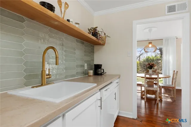 a close view of a sink a table and chairs in the kitchen