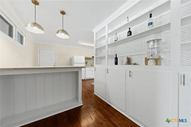a kitchen with cabinets and wooden floor