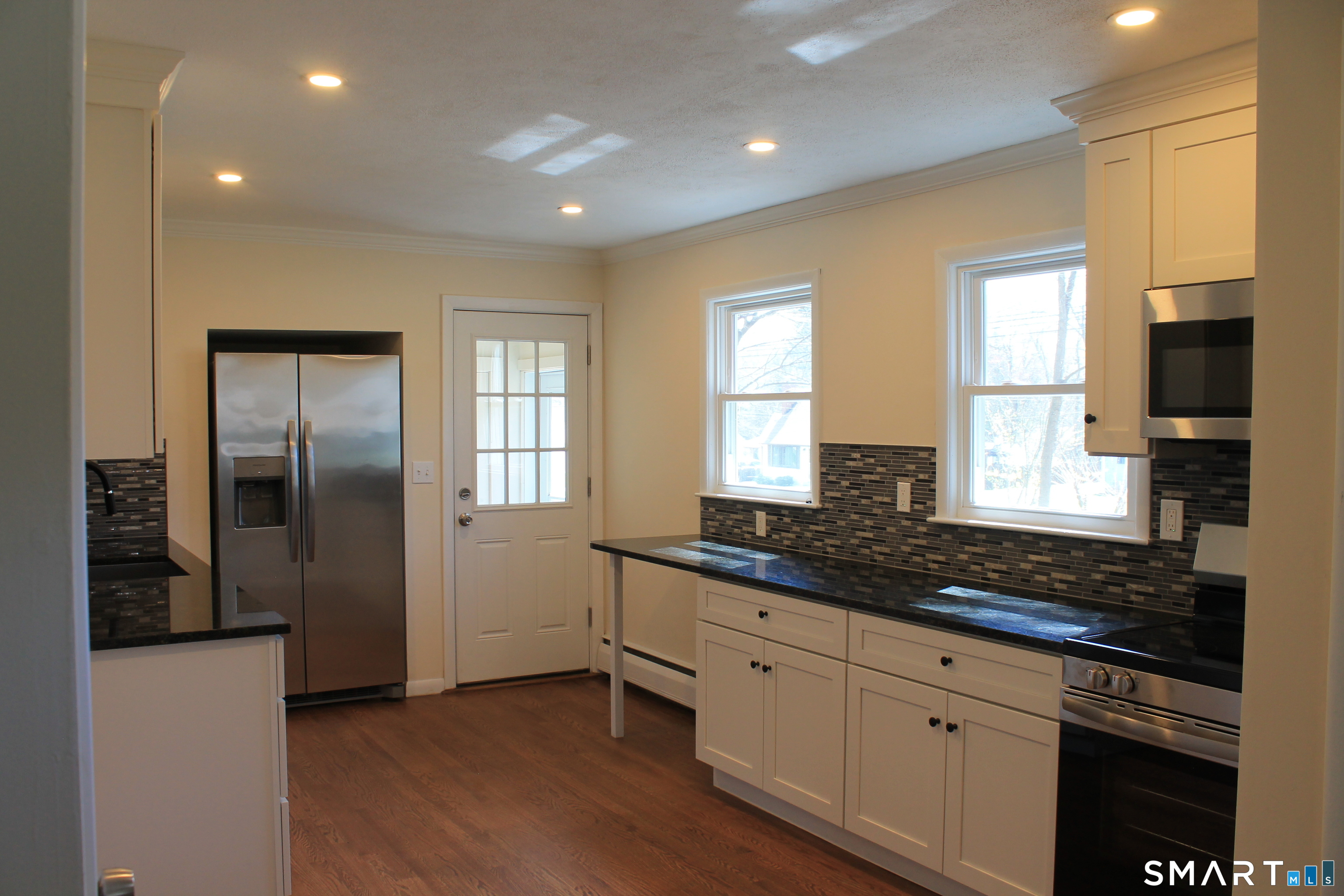 134 Sunset Street Windsor Locks, CT 06096 - Photo 7 of 23 a kitchen with granite countertop a stove a sink and a refrigerator
