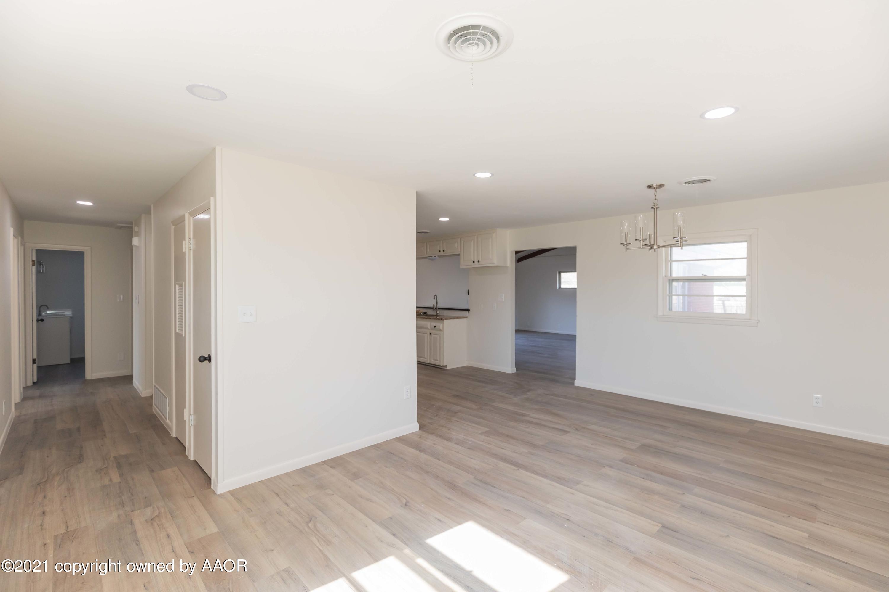 4702 South Rusk Street Amarillo, TX 79110 - Photo 14 of 36 an empty room with wooden floor and windows