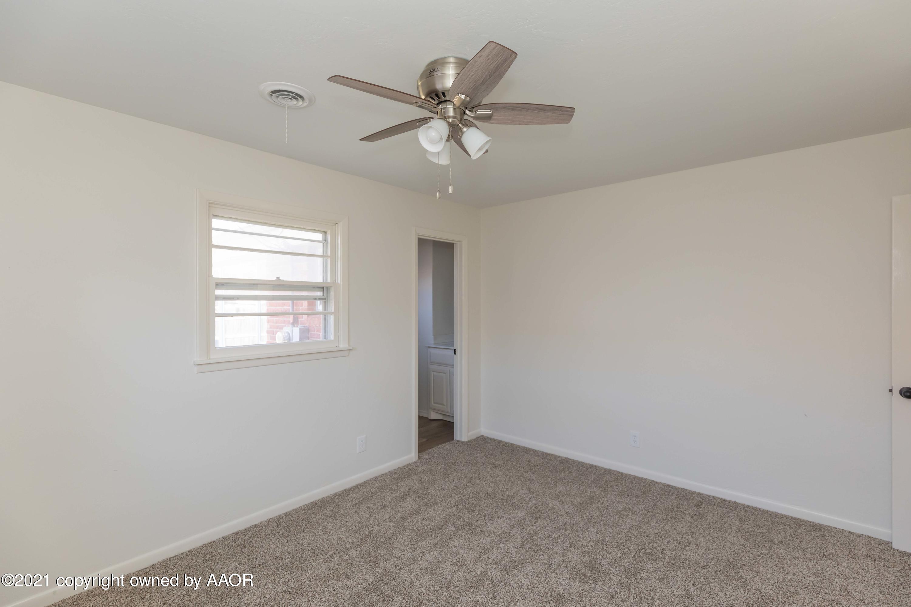 4702 South Rusk Street Amarillo, TX 79110 - Photo 18 of 36 an empty room with a window and a fan