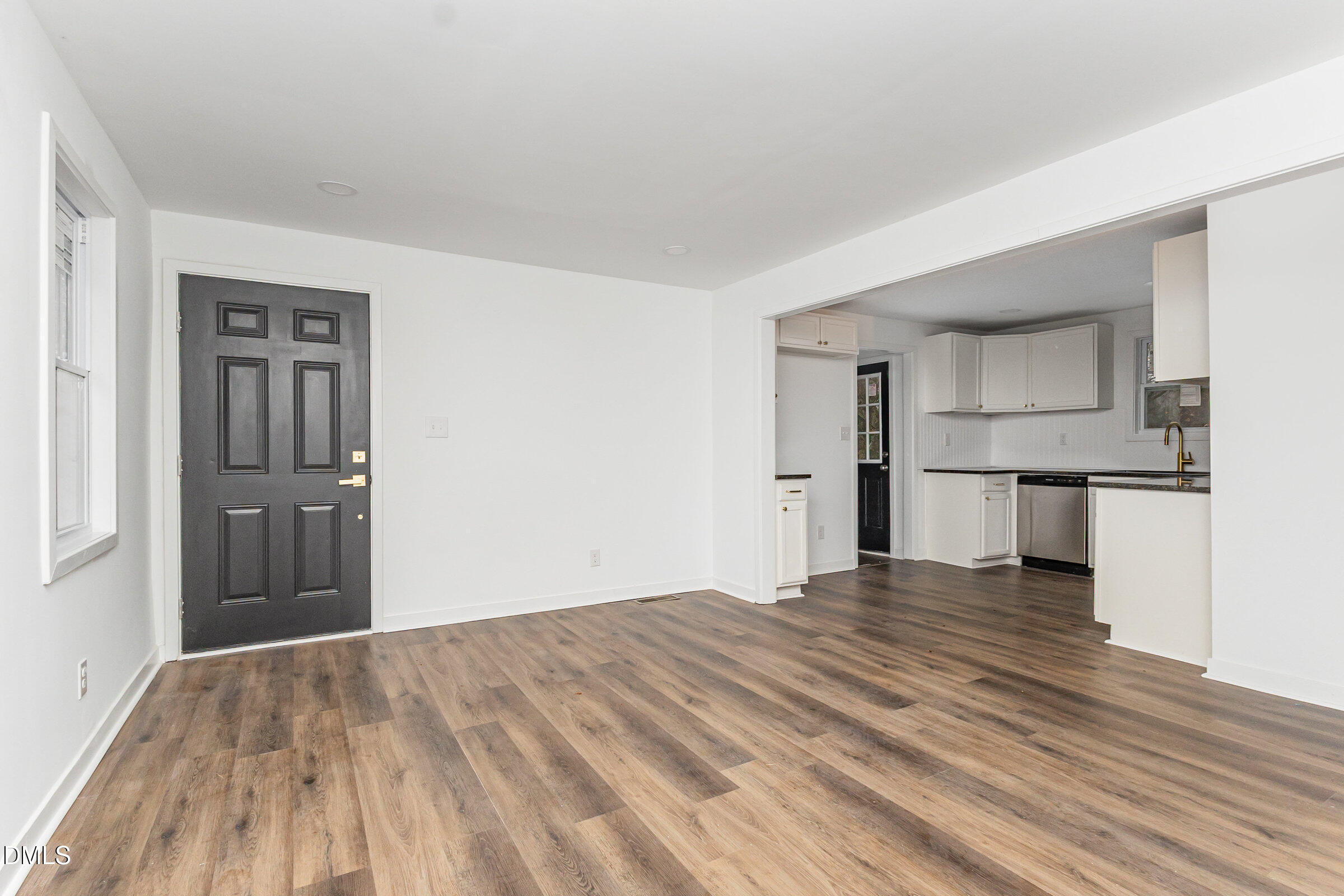 2506 Dominion Street Durham, NC 27704 - Photo 10 of 32 a view of empty room with wooden floor and kitchen