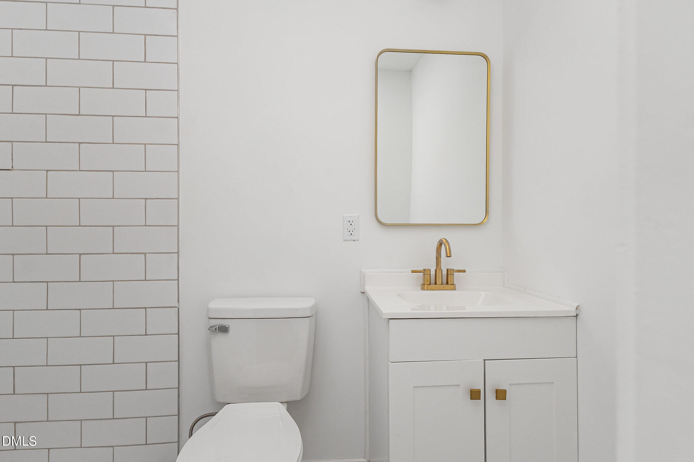 2506 Dominion Street Durham, NC 27704 - Photo 15 of 32 a bathroom with a toilet sink vanity and mirror