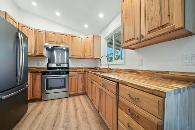 a kitchen with granite countertop a sink stainless steel appliances and cabinets