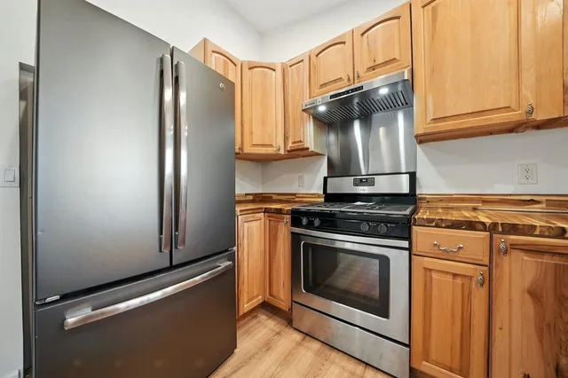 a kitchen with stainless steel appliances granite countertop a stove and a refrigerator