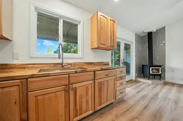 a kitchen with stainless steel appliances granite countertop a sink cabinets and wooden floor