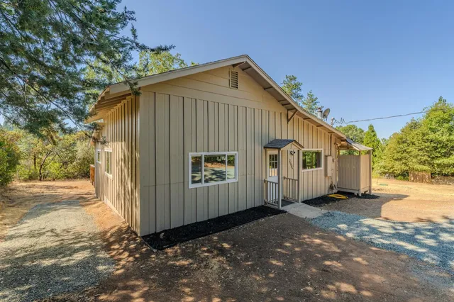 a view of a house with backyard and trees