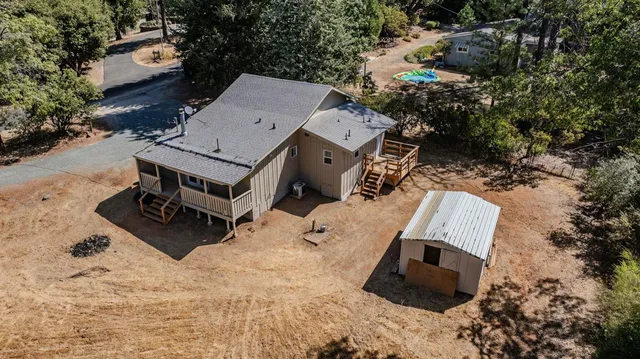 an aerial view of a house with yard and parking space
