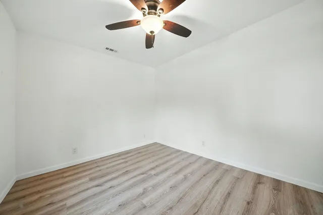 a view of an empty room with wooden floor