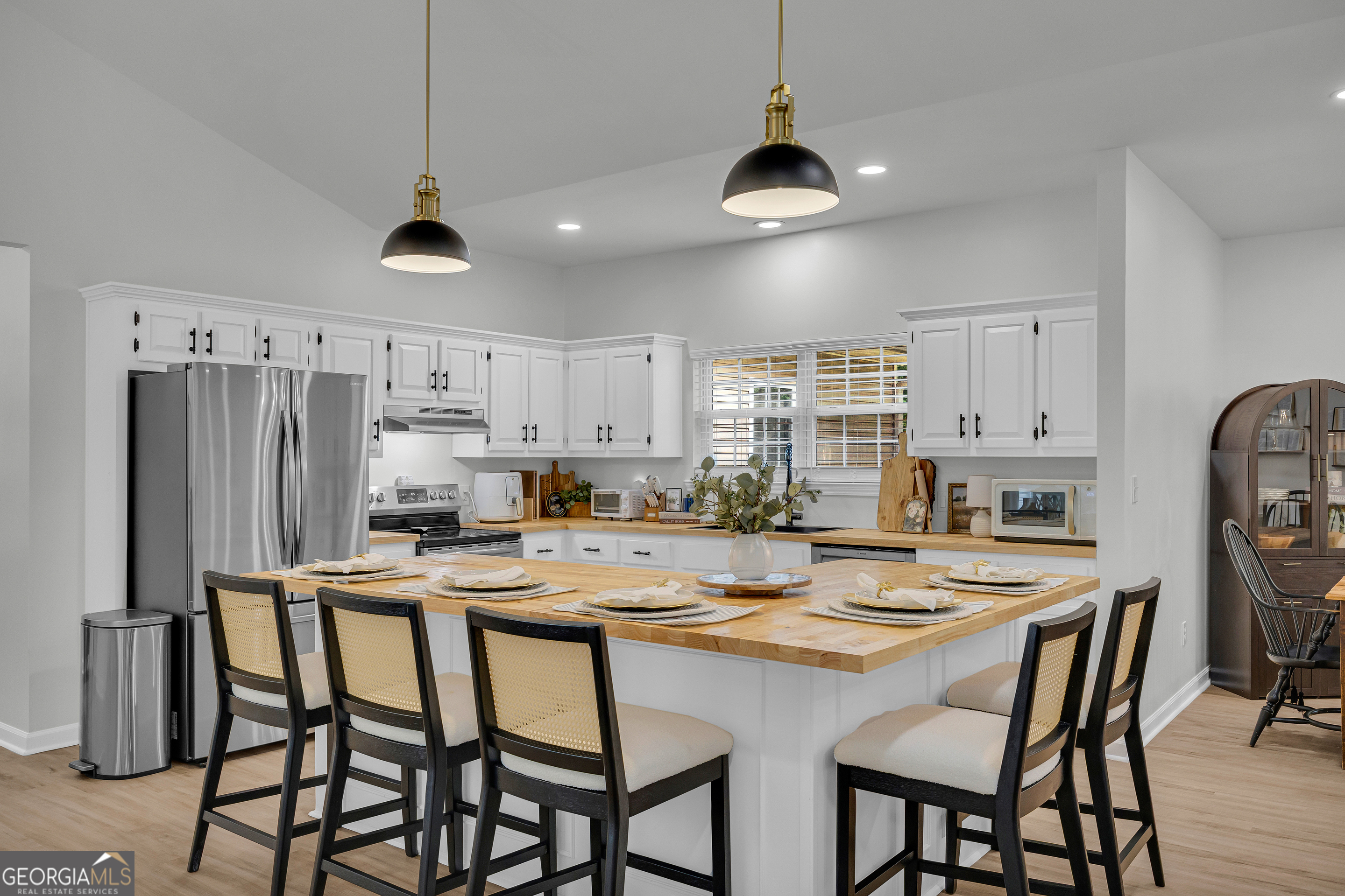 163 Tuxedo Drive Commerce, GA 30530 - Photo 22 of 62 a kitchen with stainless steel appliances a table chairs and refrigerator