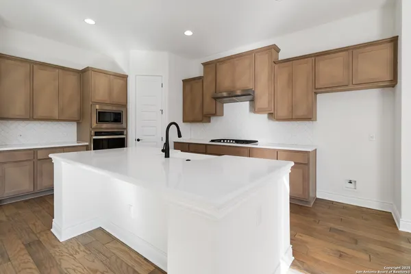 a kitchen with kitchen island white cabinets and stainless steel appliances