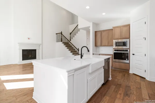 a kitchen with kitchen island a sink and a stove with wooden floor