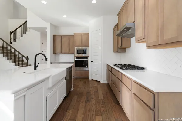 a kitchen with kitchen island a sink stainless steel appliances and cabinets