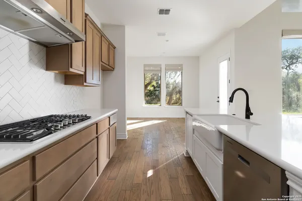 a kitchen with sink a stove and cabinets
