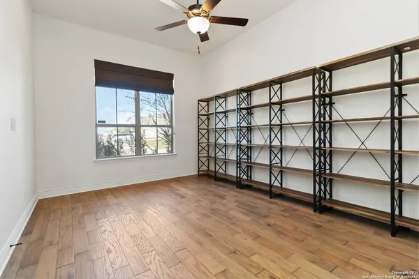 a view of an empty room with a window and wooden floor