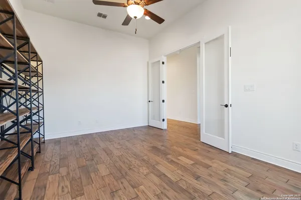 a view of an empty room with wooden floor