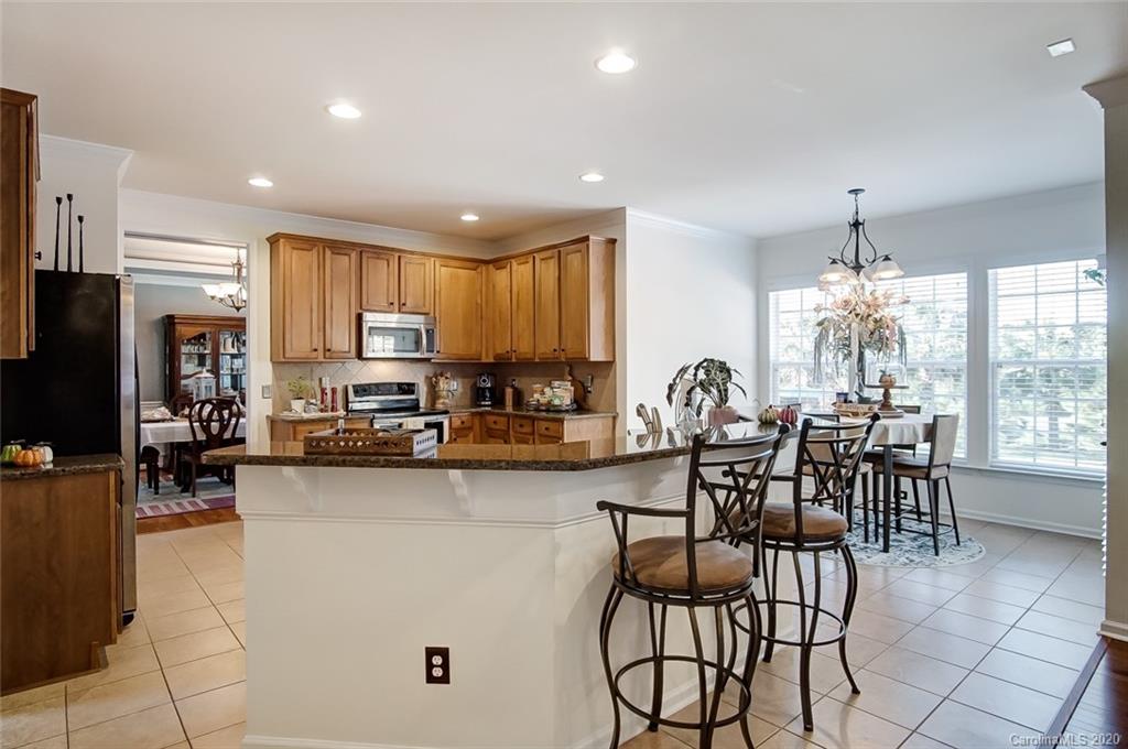 785 Fairway Point Drive Tega Cay, SC 29708 - Photo 11 of 46 a kitchen with stainless steel appliances granite countertop sink stove top oven and cabinets