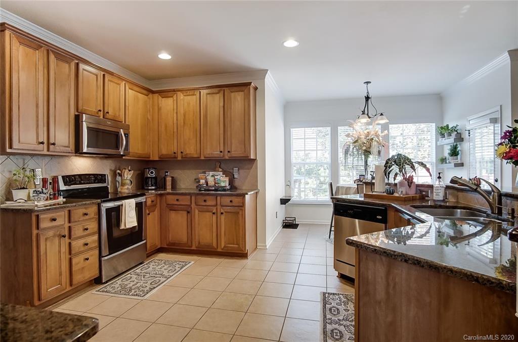 785 Fairway Point Drive Tega Cay, SC 29708 - Photo 13 of 46 a kitchen with stainless steel appliances granite countertop a stove top oven a sink dishwasher and cabinets with wooden floor