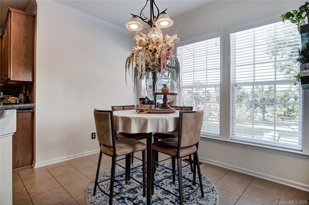 785 Fairway Point Drive Tega Cay, SC 29708 - Photo 17 of 46 a dining room with chandelier and wooden floor