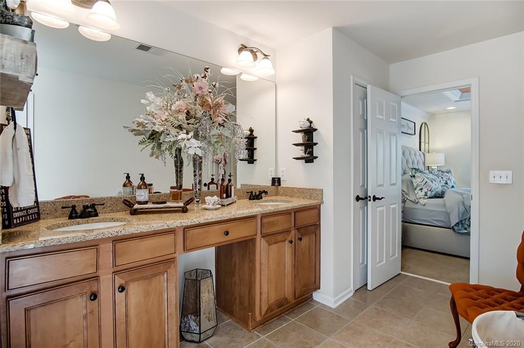 785 Fairway Point Drive Tega Cay, SC 29708 - Photo 22 of 46 a bathroom with a granite countertop sink a mirror and a shower