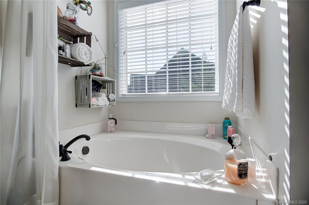785 Fairway Point Drive Tega Cay, SC 29708 - Photo 23 of 46 a white bath tub sitting in a bathroom next to a window
