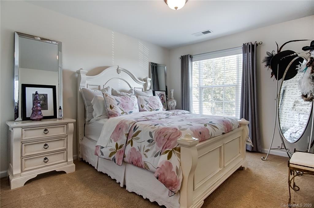 785 Fairway Point Drive Tega Cay, SC 29708 - Photo 28 of 46 a bedroom with a bed a mirror on dresser and a window