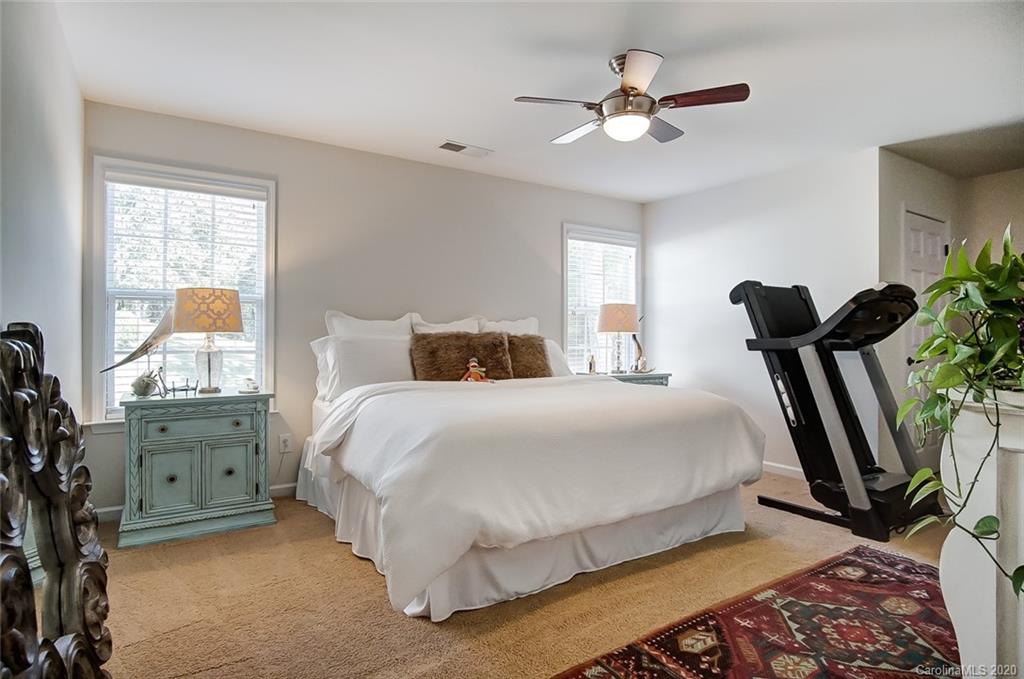 785 Fairway Point Drive Tega Cay, SC 29708 - Photo 30 of 46 a bedroom with bed and a chandelier