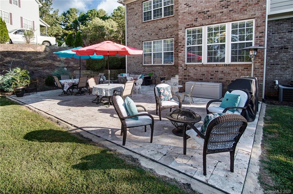 785 Fairway Point Drive Tega Cay, SC 29708 - Photo 35 of 46 a patio with a table and chairs under an umbrella