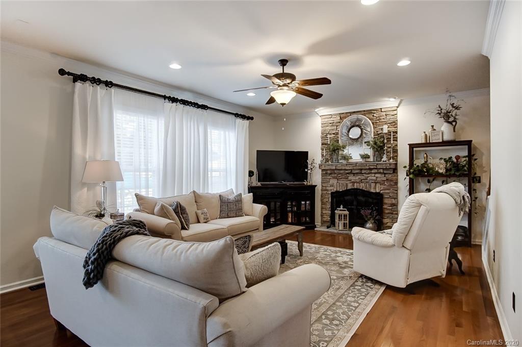 785 Fairway Point Drive Tega Cay, SC 29708 - Photo 6 of 46 a living room with furniture a fireplace and a flat screen tv