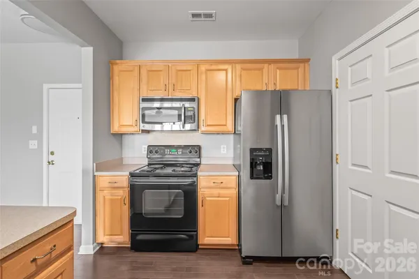 a kitchen with granite countertop white cabinets and stainless steel appliances
