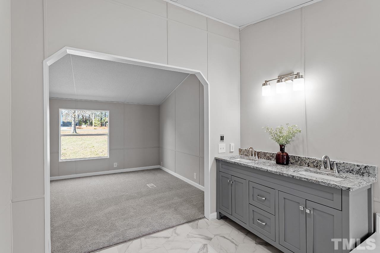 3208 State Road 2750 Willow Spring, NC 27592 - Photo 17 of 32 a bathroom with a sink and a mirror