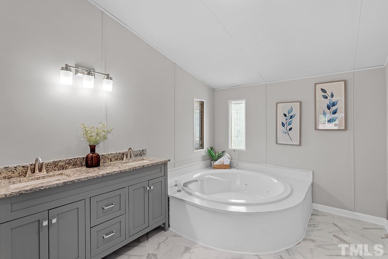 3208 State Road 2750 Willow Spring, NC 27592 - Photo 18 of 32 a bathroom with a granite countertop sink and a mirror