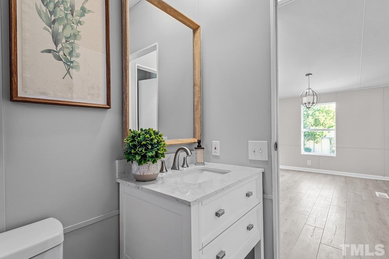 3208 State Road 2750 Willow Spring, NC 27592 - Photo 24 of 32 a bathroom with a granite countertop sink and a mirror