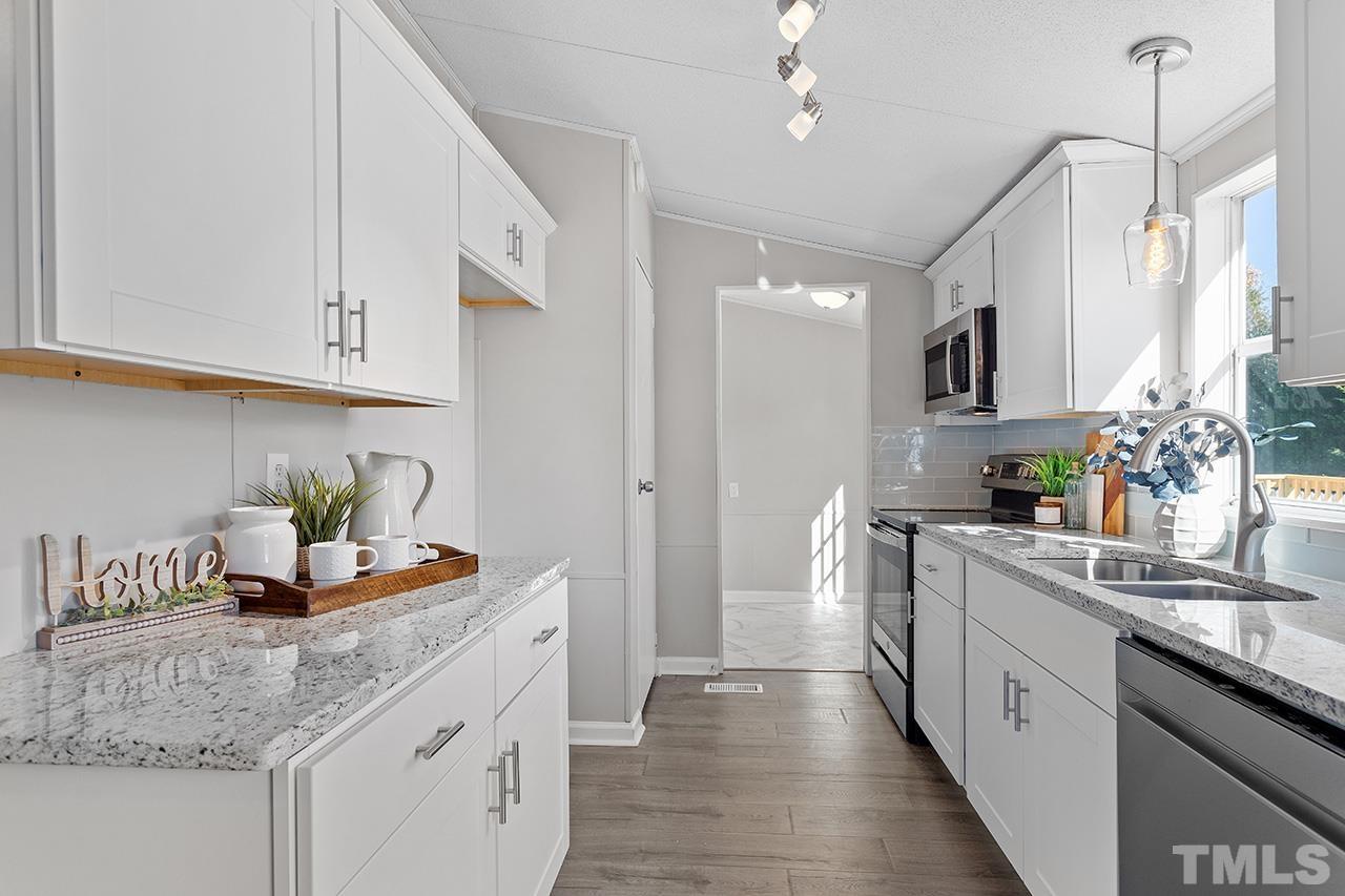 3208 State Road 2750 Willow Spring, NC 27592 - Photo 3 of 32 a kitchen with stainless steel appliances granite countertop a sink stove and refrigerator