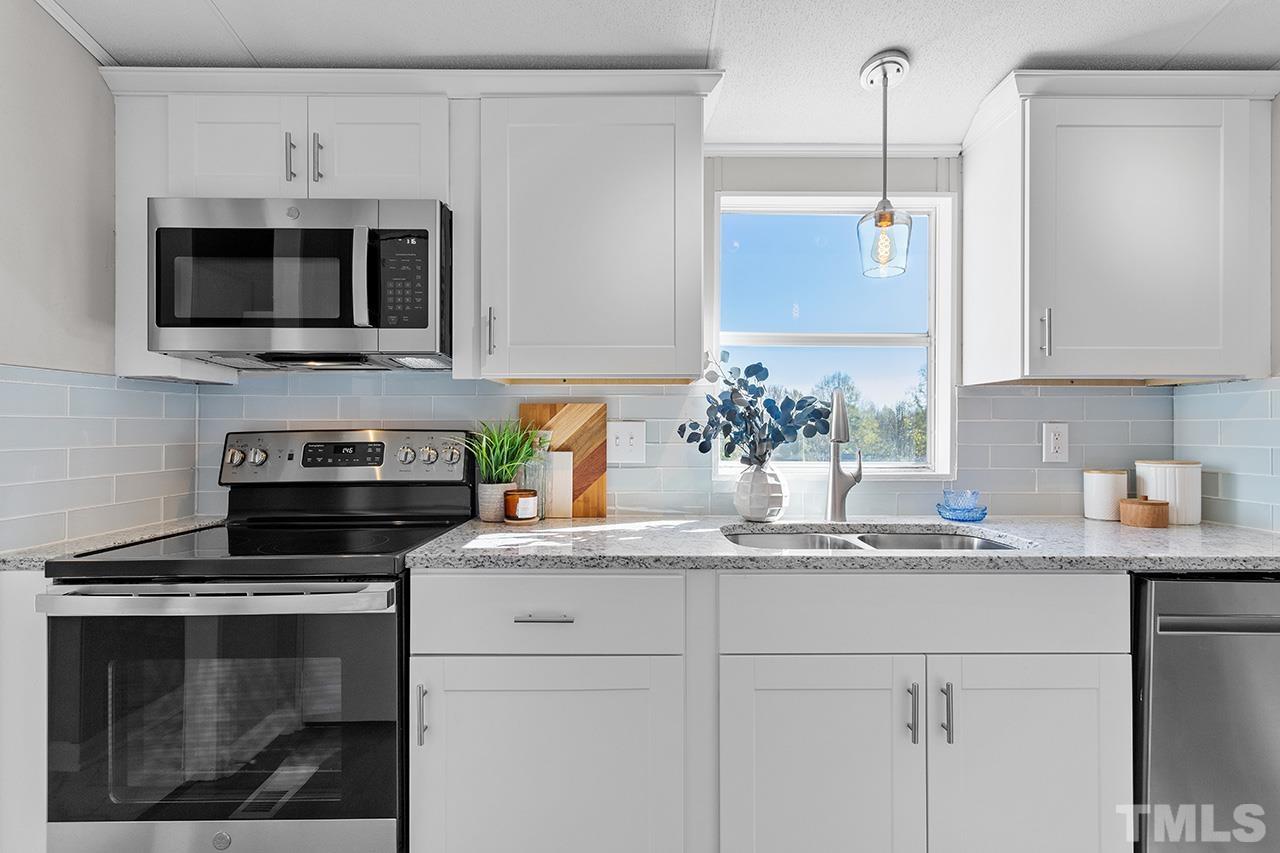 3208 State Road 2750 Willow Spring, NC 27592 - Photo 5 of 32 a kitchen with a sink stove and microwave