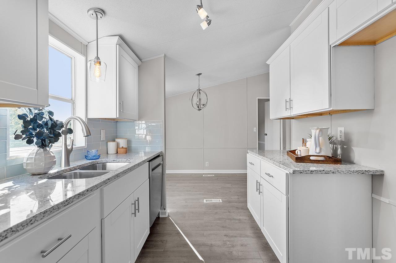 3208 State Road 2750 Willow Spring, NC 27592 - Photo 6 of 32 a kitchen with stainless steel appliances granite countertop a sink a stove and cabinets
