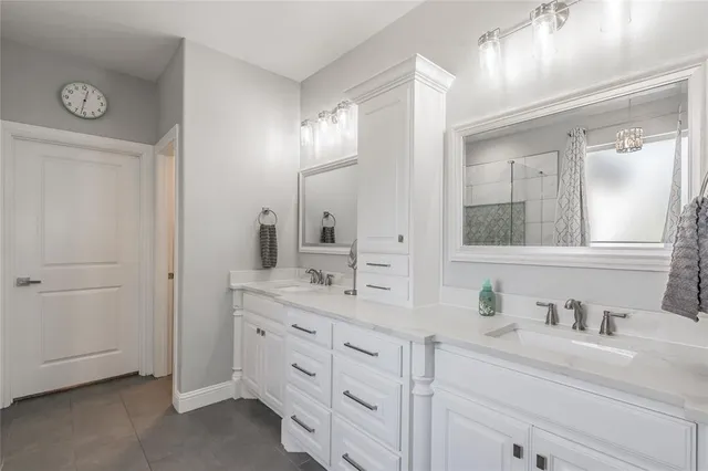 a bathroom with a granite countertop double vanity sink mirror and
