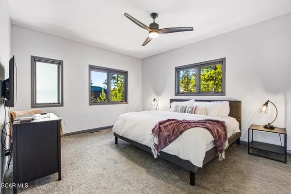 a spacious bedroom with a bed and a chandelier