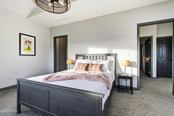 a bedroom with a bed and a chandelier