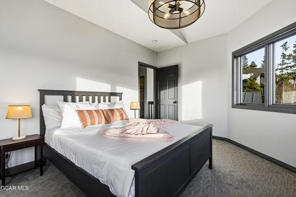 a bedroom with a bed and a chandelier