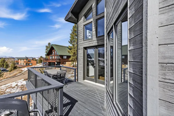 a view of a house with a yard and trees in front of it