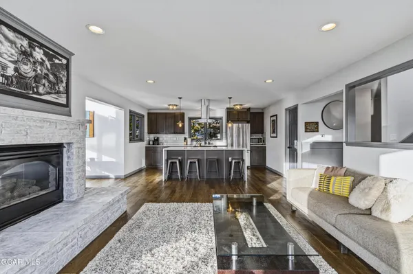 a living room with stainless steel appliances furniture and a fireplace