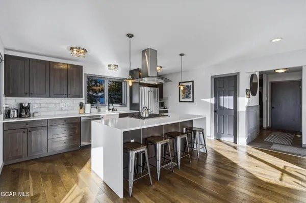 a open kitchen with stainless steel appliances granite countertop a lot of counter space and wooden floor