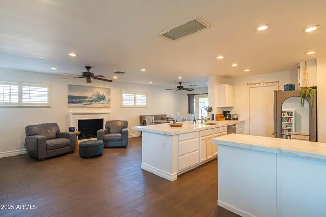 a kitchen with stainless steel appliances granite countertop a table chairs sink refrigerator and cabinets