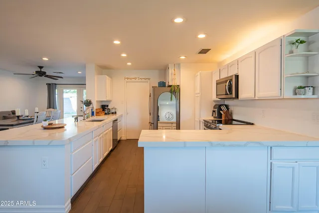 a kitchen with stainless steel appliances granite countertop a sink refrigerator and microwave