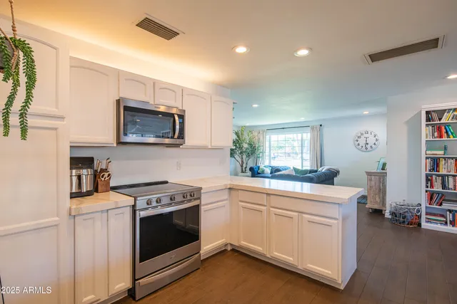 a living room with stainless steel appliances kitchen island granite countertop furniture and a large window