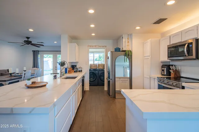 a living room with furniture a flat screen tv and kitchen view