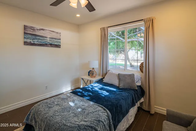 a bedroom with a bed and a flat screen tv on dresser
