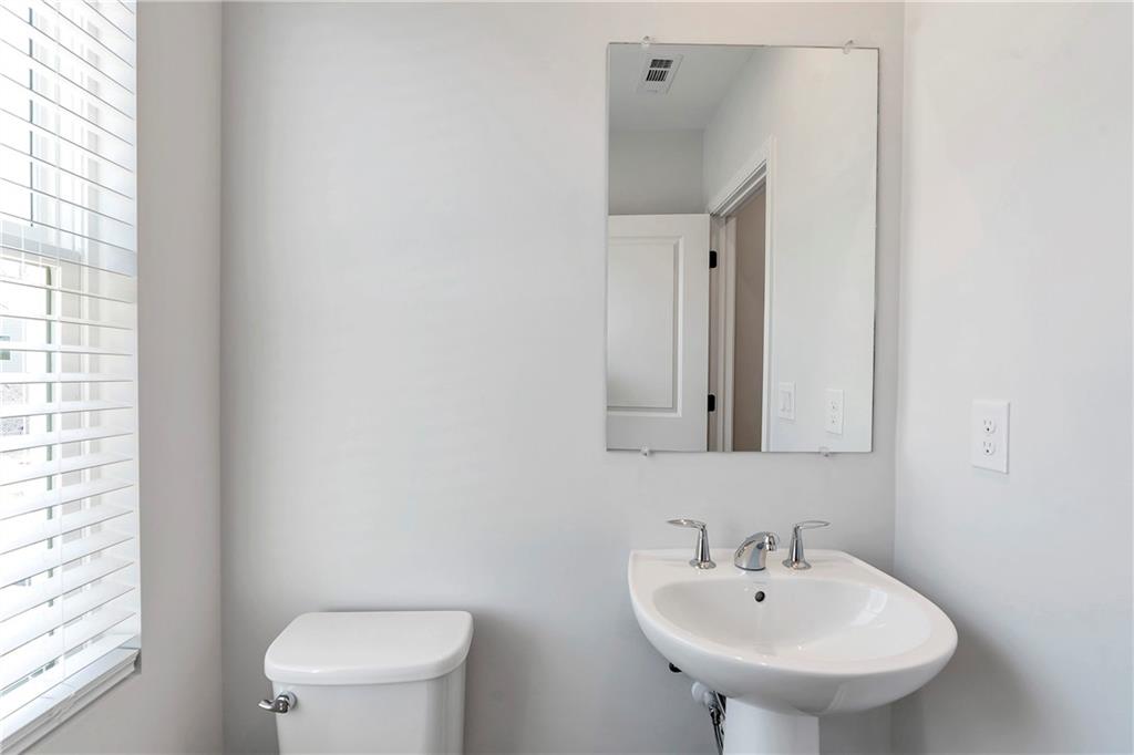 2244 Whistler Way Northeast Lawrenceville, GA 30043 - Photo 14 of 25 a bathroom with a sink a toilet and mirror