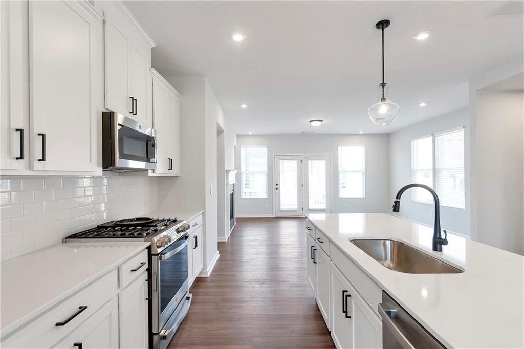 2244 Whistler Way Northeast Lawrenceville, GA 30043 - Photo 10 of 25 a kitchen with stainless steel appliances a sink a stove top oven a counter space and cabinets